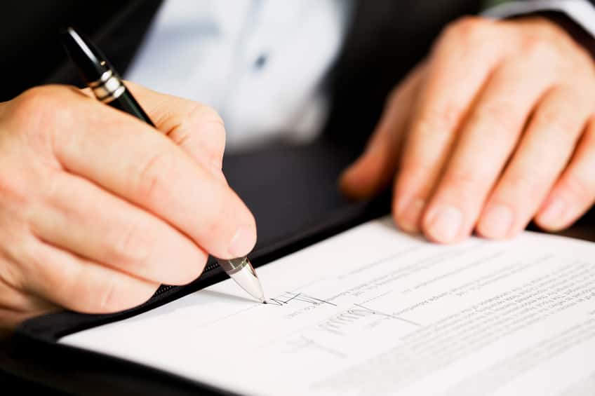 Close up of businessman signing a contract.