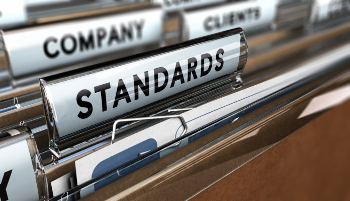 Close up on a file tab with the word standards, focus on the main word and blur effect. Concept image for illustration of quality standard